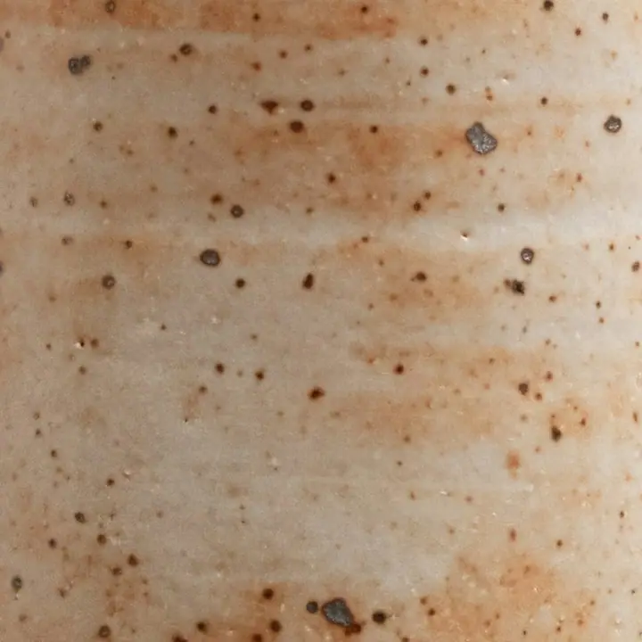 Detalhe das marcas laranja deixadas pela chama no esmalte branco