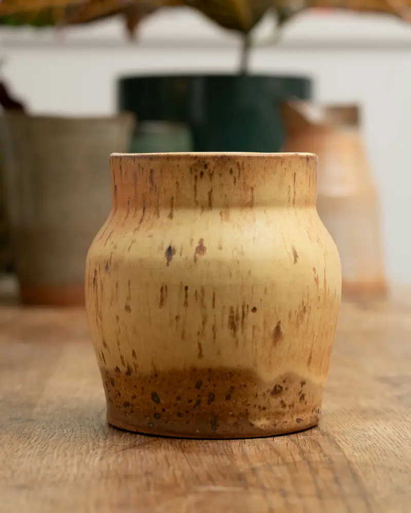 Vaso bojudo amarelo com escorridos marrons e base cor de barro