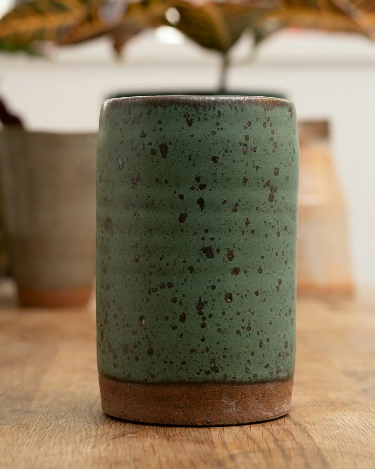 Copo alto verde com pintas escuras e base sem esmalte
