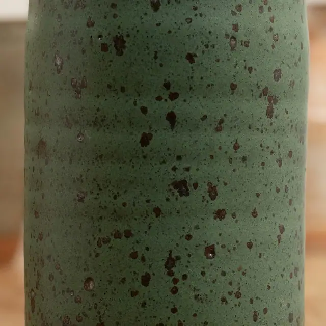Esmalte verde com pintas de manganês, de perto