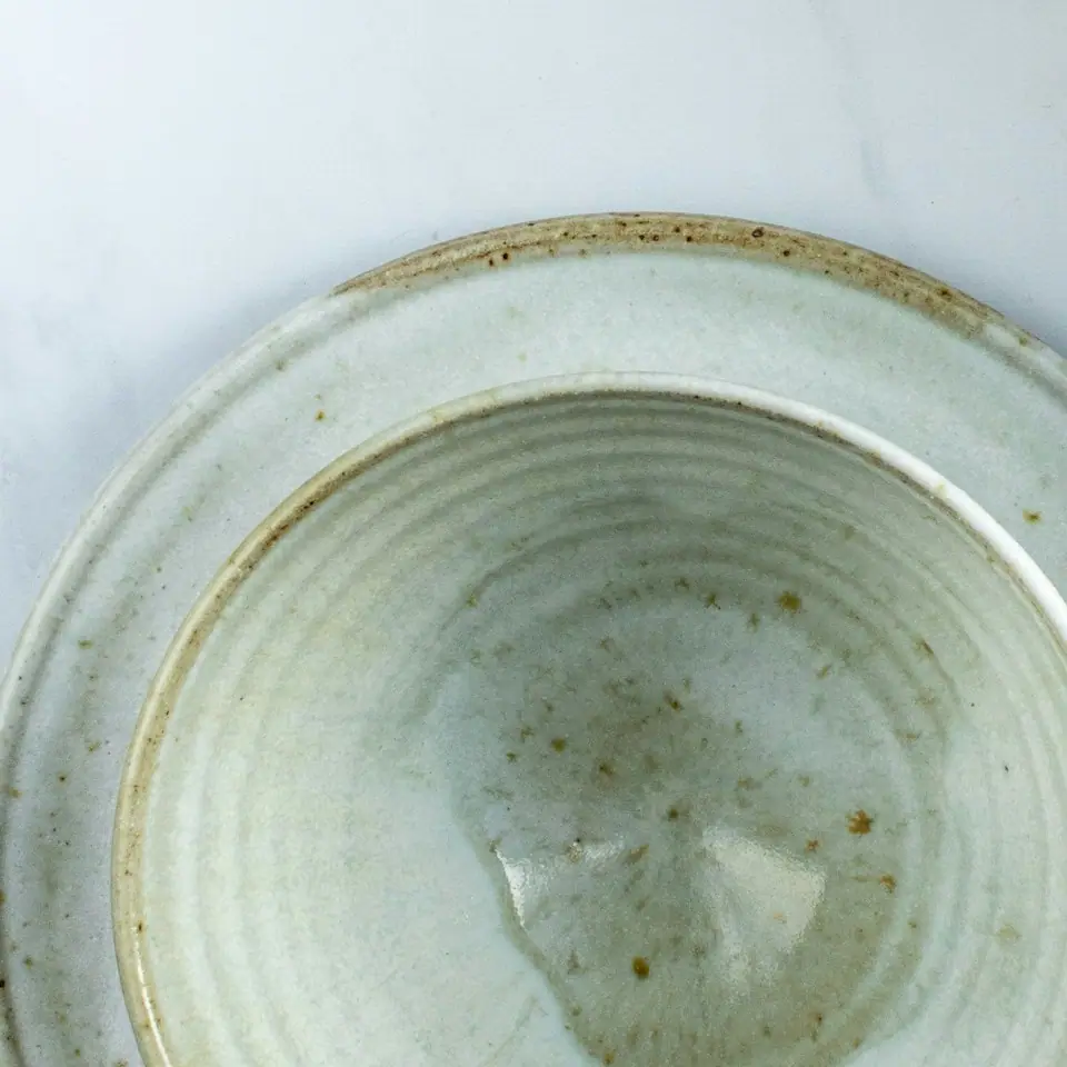 Detalhe de uma tigelinha, com a borda cor de ferro